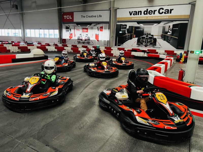 Uśmiechnięte dziecko w kasku prowadzące dedykowany dla najmłodszych gokart elektryczny modelu Puffo na bezpiecznej nitce toru.